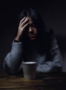 Femme triste devant son café 